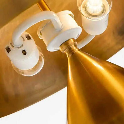 Gold pendant light with white sockets and clear bulbs, showcasing modern design.